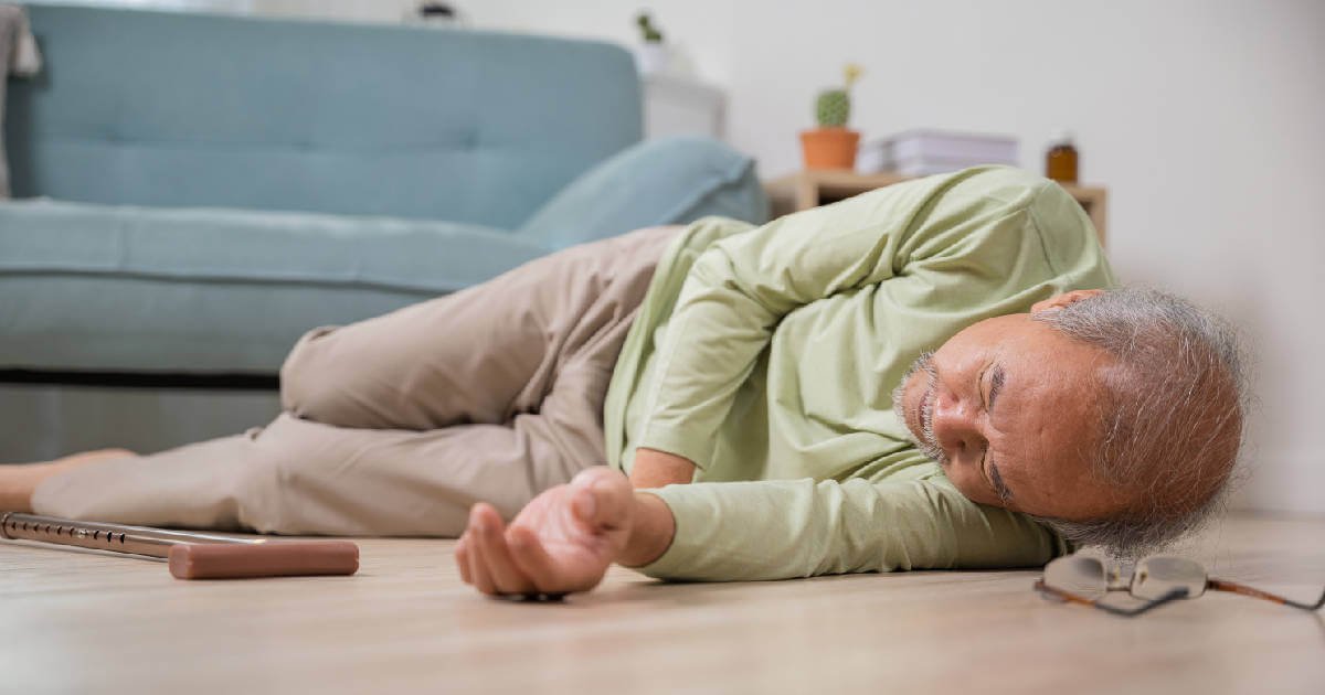 Elderly man lies on floor after a fall